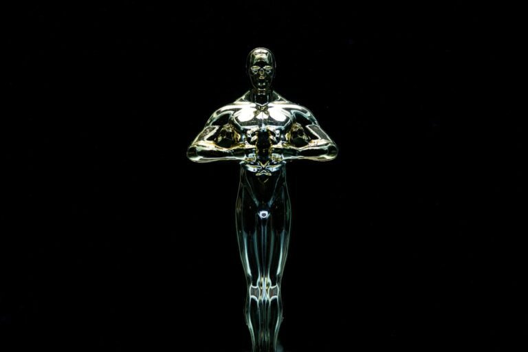 A golden trophy statue isolated on a black background symbolizing achievement and victory.